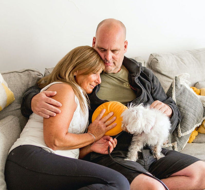 Couple relaxing with an AmpCoil device, enjoying its wellness benefits at home.