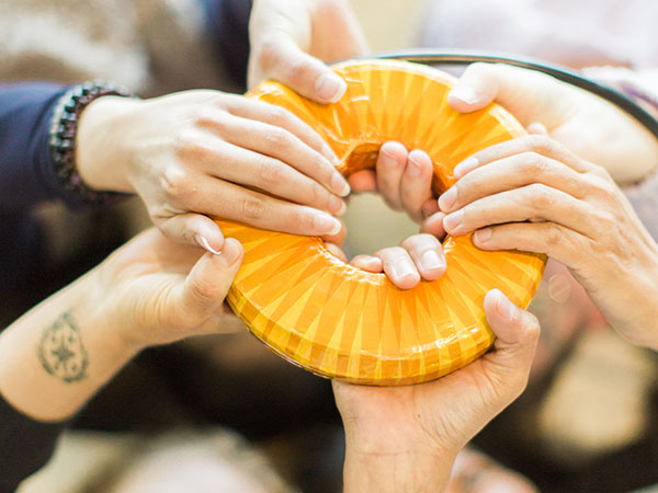 Several hands holding the AmpCoil together