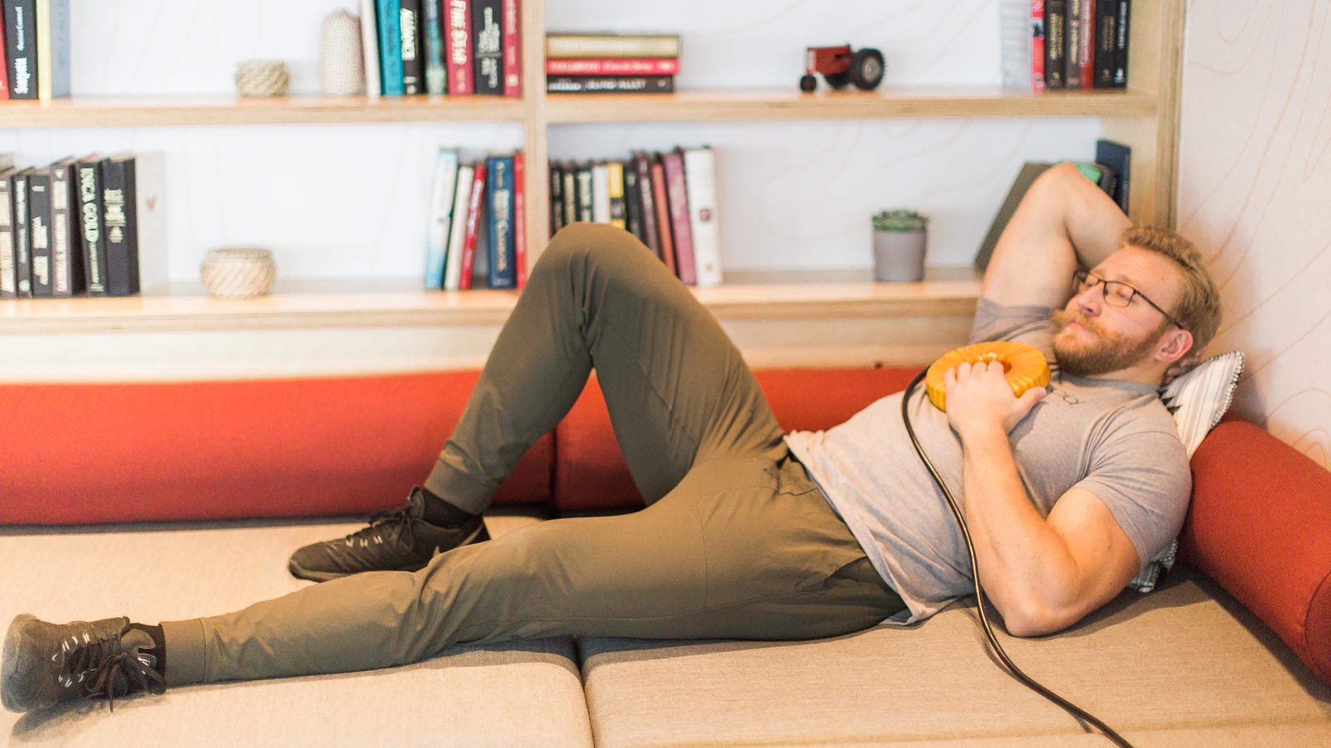 Man relaxing on a sofa with the AmpCoil resting on his chest