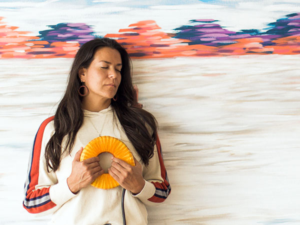 Woman holding the AmpCoil to her chest with her eyes closed