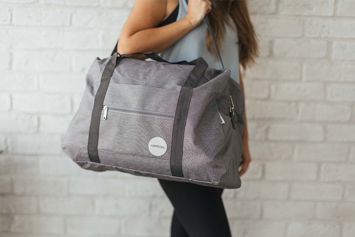Woman carrying the AmpCoil travel bag over her shoulder