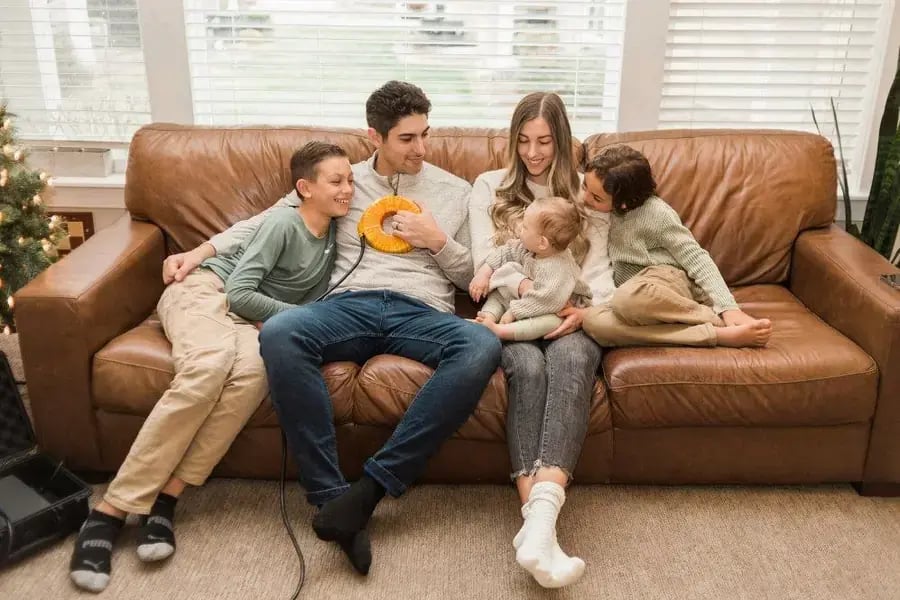 Family relaxing together on a sofa with the AmpCoil coil