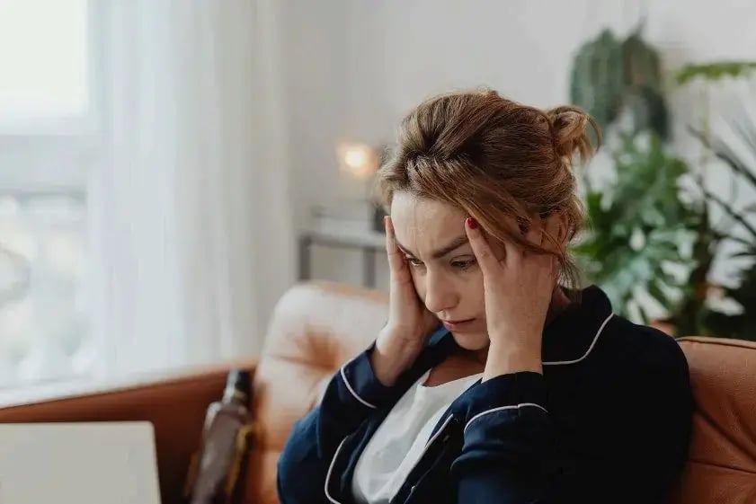 Woman holding her head, feeling overwhelmed