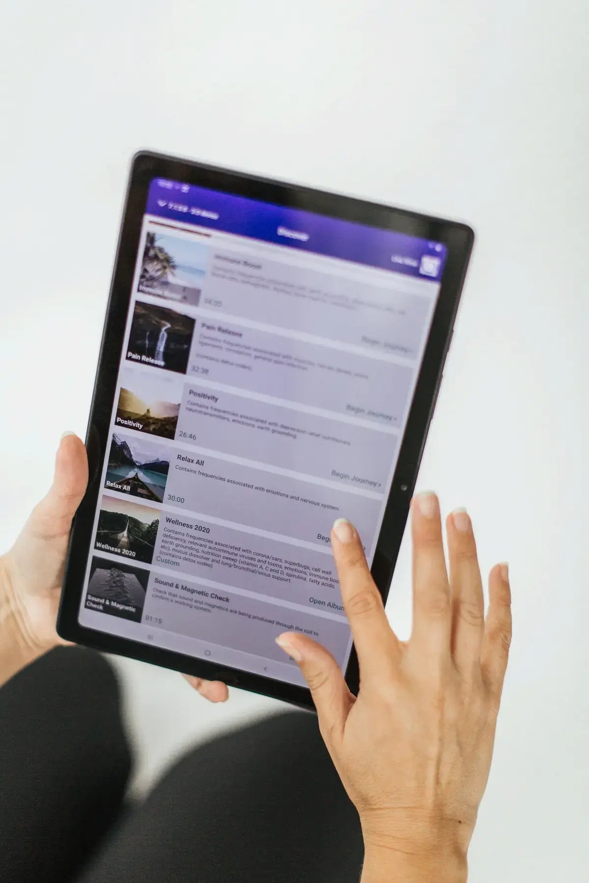 Hand holding a tablet showing the BetterGuide journey library